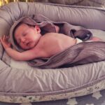 Baby schläft in einem Babynest.