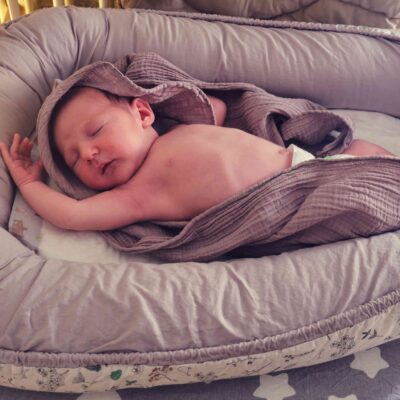 Baby schläft in einem Babynest.