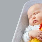 Baby kuschelt mit Spielzeug, das es als Geschenk zur Geburt bekam.