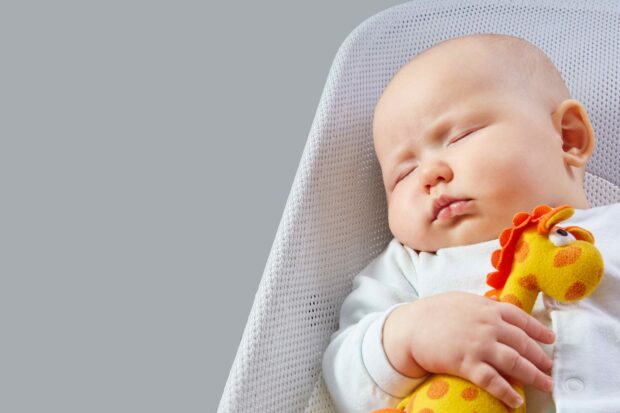 Baby kuschelt mit Spielzeug, das es als Geschenk zur Geburt bekam.