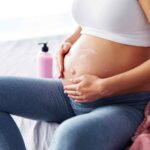 Schwangere massiert ihren Bauch, um Wehen auszulösen.